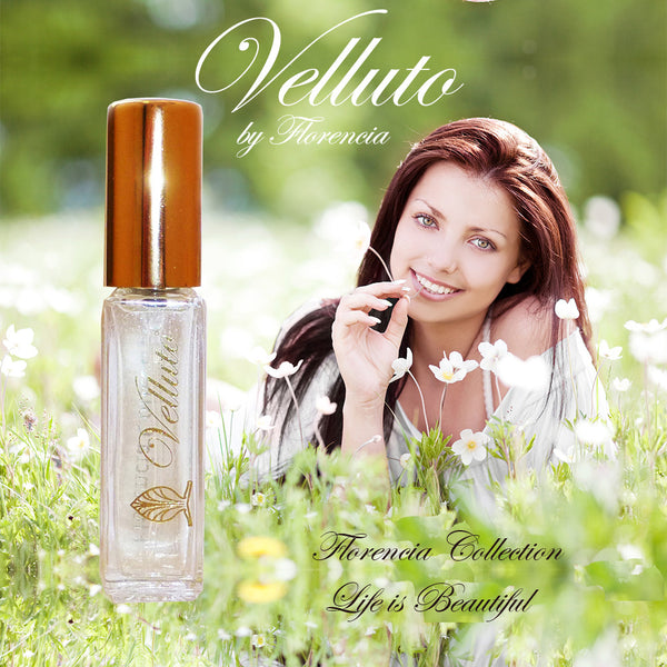 Velluto Perfume bottle with a gold top. Woman in the background laying in a field of flowers.