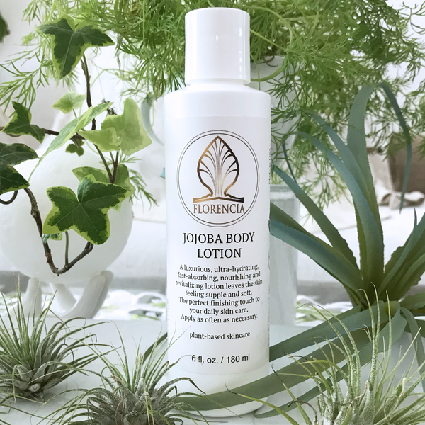 Closed Bottle of Jojoba Body Lotion by Florencia with green leafs